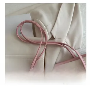Close-up of comfortable pink leather shoulder straps on a stylish large tote bag
