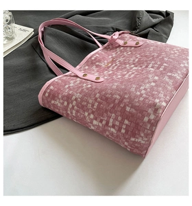 Close-up of pink woven tote bag featuring fine texture and elegant gold hardware