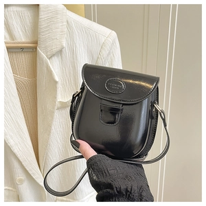 Dettaglio mini borsa a sella nera lucida con logo circolare PUCCING FASHION in rilievo