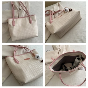 Detail view of large houndstooth tote bag showing spacious interior and plush charm