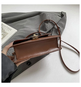 Détail de la structure du sac en cuir marron avec un fermoir en métal doré