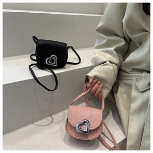 Nahaufnahme der Mini-Taschen aus strukturiertem Leder mit Herzschnallen in Schwarz und Rosa