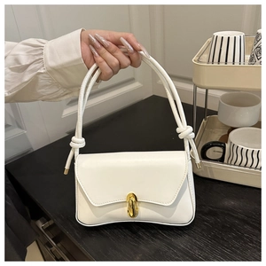 Detail of white PU leather shoulder bag with golden spherical lock and knotted strap
