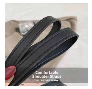 Detail of the black leather shoulder strap with durable double stitching and fine grain texture