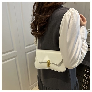 Detail of minimalist cream PU leather shoulder bag with gold oval twist lock closure