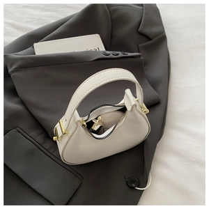 Close-up of a white leather half-moon handbag with black zipper and gold hardware detail