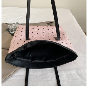 Top view of pink quilted tote bag showing spacious black interior and zipper pocket