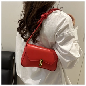 Red leather shoulder bag with gold metal lock and knotted strap shown on model