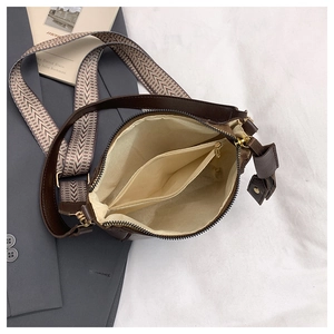 Detail view of the brown leather bucket bag interior with wide zigzag strap