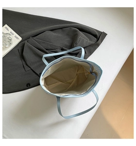 Top view of spacious light blue tote bag showing the zipper closure and beige fabric lining