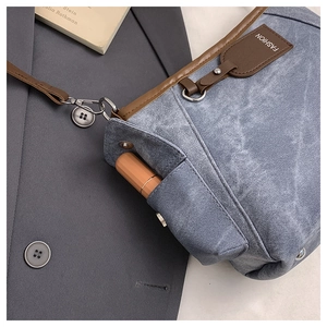 Close-up of denim texture tote bag with side pocket for lipstick storage and brown trim
