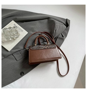 Détail d'un sac en cuir marron avec rabat imprimé léopard et accessoires en métal doré chic