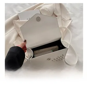 Interior view of white studded flap bag showing space for phone and essentials