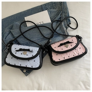 Détail de sacs à nœuds rose et bleu avec pendentifs en cœur sur un tissu blanc propre