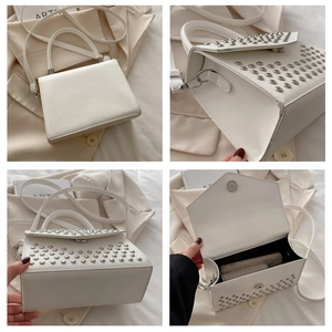 Detail view of white leather crossbody bag with silver studs and internal storage