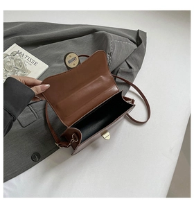Vue intérieure du sac bandoulière en cuir marron avec fermoir doré et doublure noire