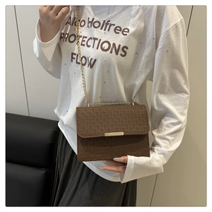 Detailed view of brown woven texture leather crossbody bag with gold chain strap