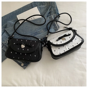 Détails de sacs bandoulière plissés avec des nœuds noirs et breloques en forme de cœur