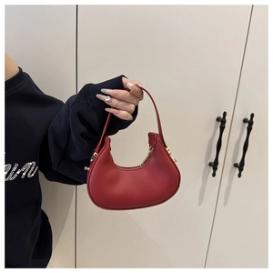 Close-up of red leather hobo handbag featuring gold zipper and elegant matte texture