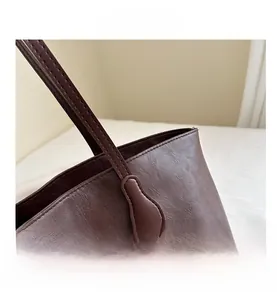 Dettaglio delle cuciture rinforzate e della texture in pelle morbida su una borsa marrone