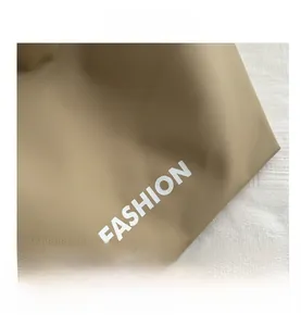 Detail aus khakifarbenem Nylongewebe mit markantem weißem Fashion-Schriftzug-Aufdruck