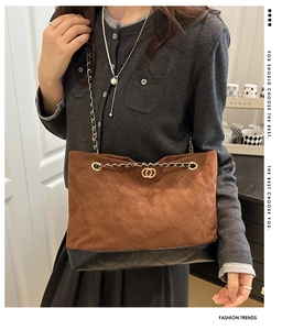 Détail du sac matelassé avec bandoulière chaîne dorée et finition en daim marron
