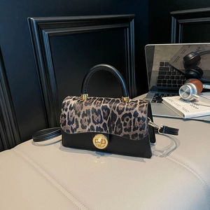 Sac bandoulière vintage léopard avec fermoir tournant doré sur cuir noir élégant