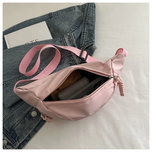 Detailed interior of a pink nylon crossbody bag showing storage for phone and accessories