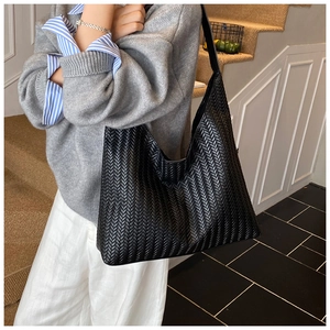 Close-up of a premium black woven leather hobo bag with iconic Intrecciato pattern texture