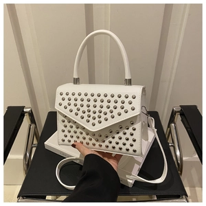 Detail of white leather handbag with silver metallic rivets and structured top handle