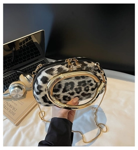 Detail of leopard print clutch with golden round handle and detachable chain strap