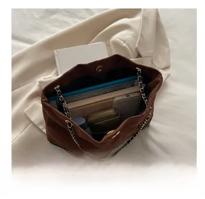 Vue intérieure d'un sac cabas en daim marron montrant sa grande capacité et sa bandoulière
