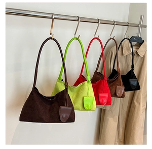 Detail view of multi-color suede crossbody bags in brown, green, red and black