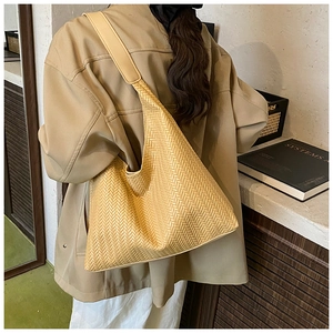 Detailed view of beige woven tote bag with a soft texture and matching wide shoulder strap