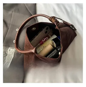 Spacious interior of brown suede hobo bag showing daily makeup and phone storage