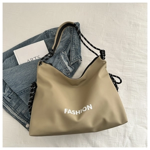 Detailansicht der khakifarbenen Tragetasche mit FASHION-Print und gewebtem Tragegurt