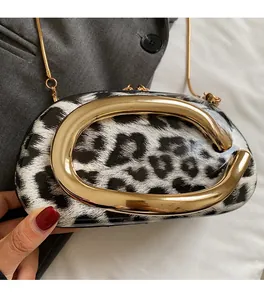 Detail of leopard print crossbody bag with large gold metal clasp and chain strap