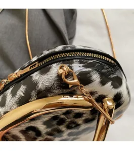 Close-up of leopard print patent leather bag with gold hardware and chain strap