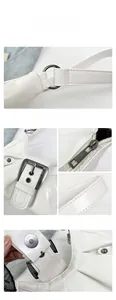 Close-up of vintage silver hardware buckles and stitching on white pleated leather bag