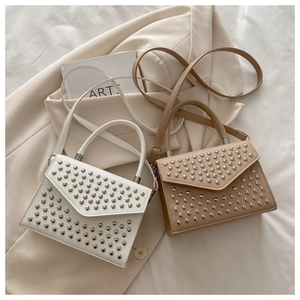 Close-up of stylish retro handbags featuring silver studs and adjustable leather straps