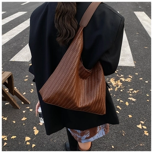 Close-up of a woven dark brown shoulder bag with a stylish vintage texture