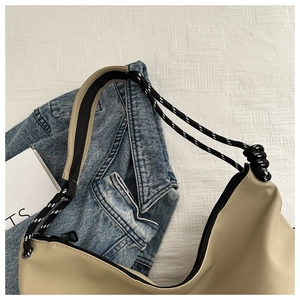 Détail d'un sac hobo kaki avec bandoulière en corde tressée noire et blanche