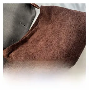 Close-up of the brown faux suede texture and premium stitching on the shoulder bag