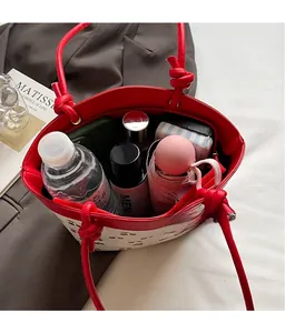 Spacious interior of cherry print tote bag holding water bottle and umbrella