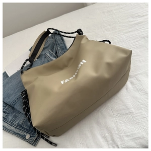 Détail du sac à bandoulière en toile kaki avec imprimé FASHION et sangle en corde