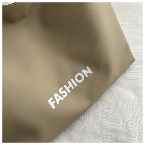 Gros plan du sac fourre-tout kaki avec inscription FASHION blanche sur tissu nylon