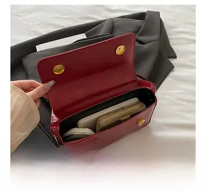 Interior view of red patent leather crossbody bag showing capacity for daily essentials