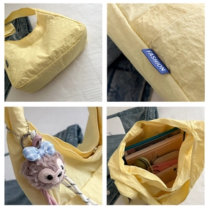 Detail view of large capacity nylon tote bag with blue fashion label and plush charm