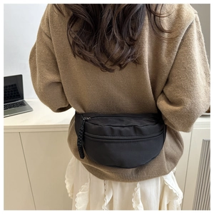 Detail van minimalistische zwarte canvas crossbodytas met textuur en ritsontwerp