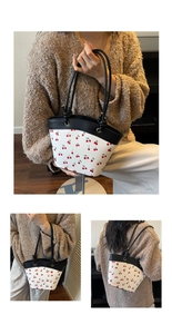 Detail view of cherry print tote bag showing various hand-carrying and shoulder styling ways